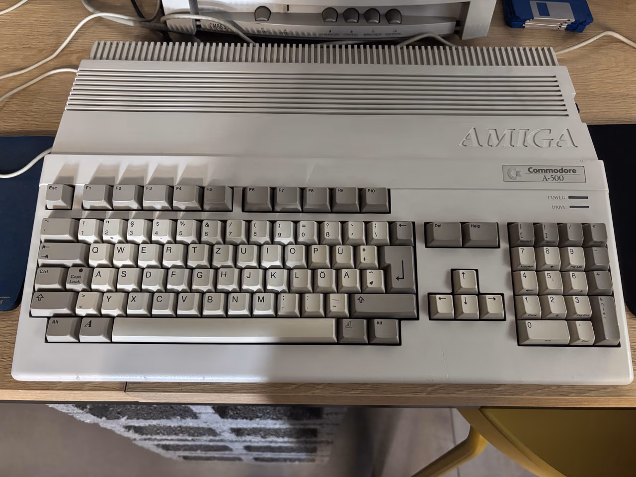 A gray Commodore Amiga 500 seen from above, a full keyboard with a numeric pad in a wedge-shaped case, the Amiga name molded into the top right.
