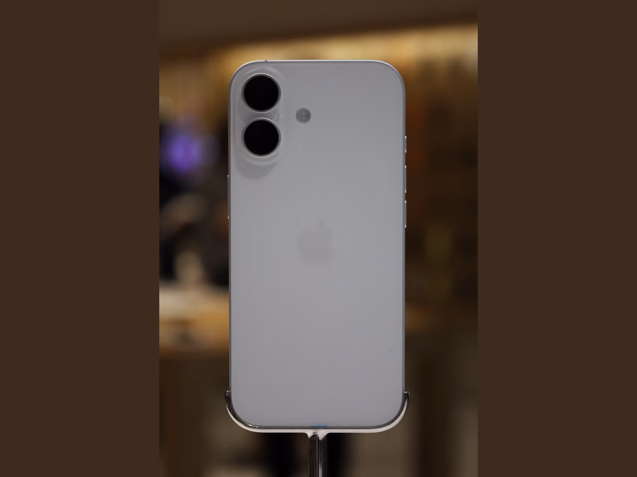 A white Apple iPhone 17 shown upright from the rear, with its two cameras at the upper left.