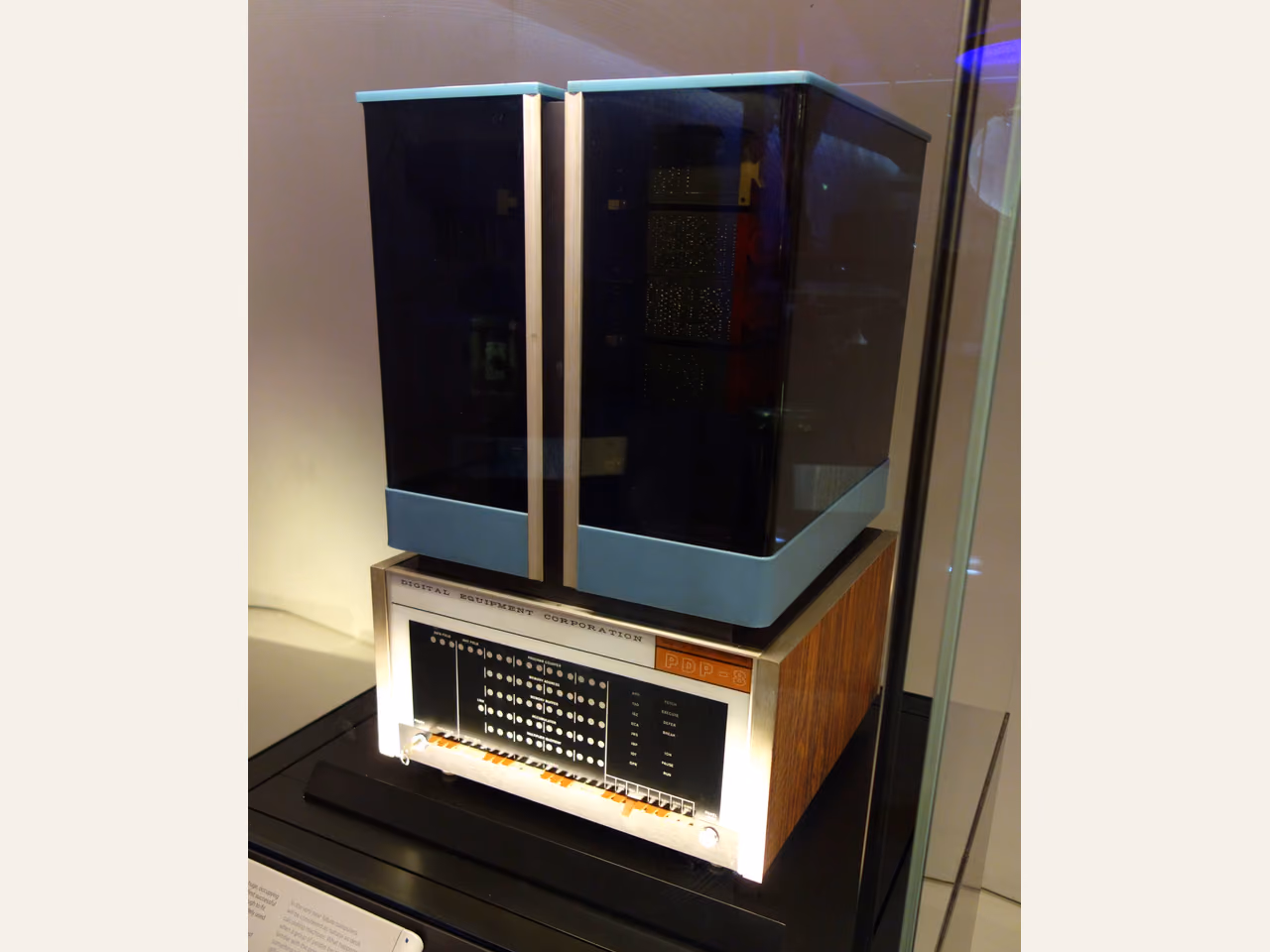 A DEC PDP-8 in a museum, with a tall dark enclosure above a beige front panel of indicator lamps and toggle switches.