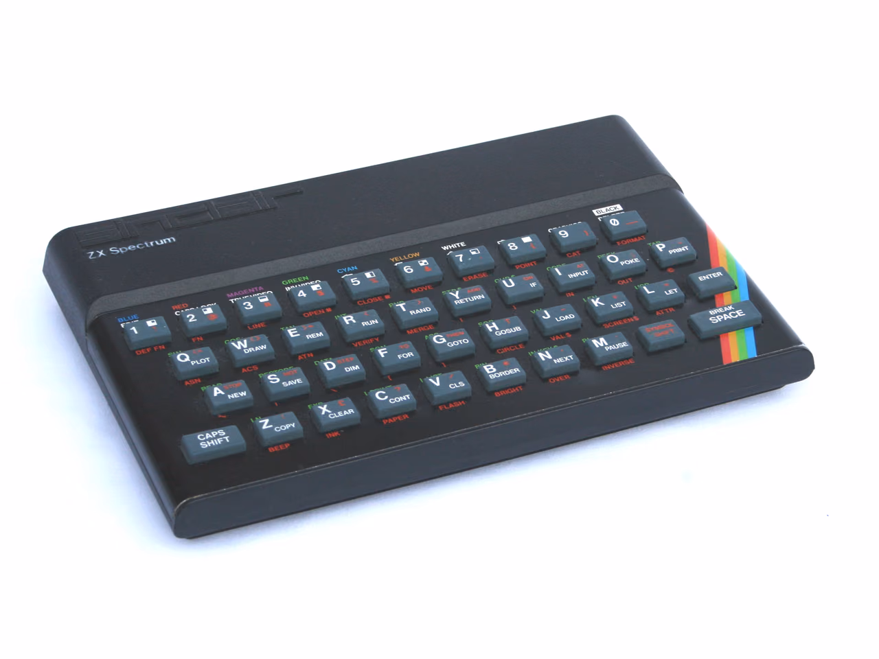 A black ZX Spectrum photographed against white at an angle, its gray rubber keys printed with several commands each and a rainbow flash across the bottom right corner.